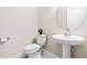 Powder room with white pedestal sink, matching toilet, neutral paint and tile flooring at 7945 Parker Mill Trail, Fuquay Varina, NC 27526