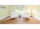 A cozy sitting area features large windows that provide ample natural light, carpet, and neutral paint at 7945 Parker Mill Trail, Fuquay Varina, NC 27526
