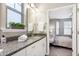 Bathroom featuring granite counters, white cabinets, window, and decor with an adjacent bedroom at 1009 Santiago St, Durham, NC 27703