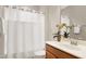 Bathroom with a single sink vanity, mirror, lighting, and an orchid in the corner at 1009 Santiago St, Durham, NC 27703
