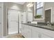 Bathroom featuring a dual sink vanity with granite countertops, and a glass enclosed walk-in shower at 1009 Santiago St, Durham, NC 27703