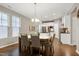Bright dining area features wood floors, table with seating and modern lighting fixtures, adjacent to kitchen with stainless steel appliances at 1009 Santiago St, Durham, NC 27703