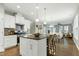 Stylish kitchen showcasing an island with barstool seating, pendant lights, and seamless flow into the dining and living areas at 1009 Santiago St, Durham, NC 27703