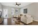 Cozy living room features comfortable seating, neutral color palette, ceiling fan, and ample natural light through well-placed windows at 1009 Santiago St, Durham, NC 27703