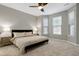 Serene main bedroom with carpet, ceiling fan, neutral tones, bedside lamps and ample natural light from multiple windows at 1009 Santiago St, Durham, NC 27703