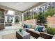 Inviting screened porch with comfortable wicker furniture and views of landscaped backyard with mature trees at 1009 Santiago St, Durham, NC 27703