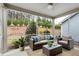 Relaxing screened porch featuring wicker furniture, ceiling fan, and serene views of the landscaped backyard at 1009 Santiago St, Durham, NC 27703