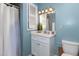 Clean bathroom with light blue walls, white vanity, and a shower at 101 Monterey Ln, Durham, NC 27713