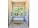 Bathroom featuring soaking tub with marble tile surround at 109 Evander Way, Pittsboro, NC 27312