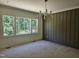 Serene bedroom with large windows offering picturesque views and panel accent wall at 109 Evander Way, Pittsboro, NC 27312