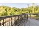 Wooden deck with black metal railings overlooking a lush, wooded backyard at 109 Evander Way, Pittsboro, NC 27312