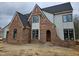 Brick and siding construction features black window frames and arched doorway at 109 Evander Way, Pittsboro, NC 27312