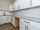 A well-appointed kitchen features white cabinetry, a gray countertop, and stainless hardware at 109 Evander Way, Pittsboro, NC 27312