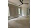 Empty bedroom with decorative trim, large windows offering natural light, ceiling fan, and unfinished floors at 129 Windel Dr, Raleigh, NC 27609