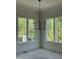 Bedroom with a modern light fixture and large windows offering natural light and outdoor views at 129 Windel Dr, Raleigh, NC 27609