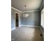 An empty dining room featuring wainscotting, a modern light fixture, and unfinished floors at 129 Windel Dr, Raleigh, NC 27609