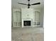 Spacious living room with a fireplace, built-in shelving, ceiling fan, and unfinished floors at 129 Windel Dr, Raleigh, NC 27609