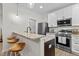 Kitchen with stainless appliances, granite counters, a bar, and modern lighting at 1300 Broad St # A, Durham, NC 27705