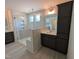 This bathroom features a shower, vanity, mirror and dark cabinets for storage with modern fixtures at 19 Grassland Dr, Garner, NC 27529