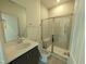 Modern bathroom featuring a glass-enclosed shower, and a vanity with sleek countertops and storage at 19 Grassland Dr, Garner, NC 27529