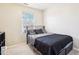 Simple bedroom with gray bedding and a window with blinds at 207 Hampshire Downs Dr, Morrisville, NC 27560