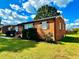 Side view of brick ranch house showcasing its brick facade and lawn at 2923 Mckinney St, Burlington, NC 27217