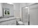 A well-lit bathroom with a granite countertop vanity, a modern toilet, and a glass-enclosed shower at 433 Rowe Way, Knightdale, NC 27545