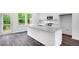 Bright, modern kitchen features a granite island, stainless steel appliances, and wood flooring at 433 Rowe Way, Knightdale, NC 27545