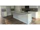 Modern kitchen island with white cabinetry and quartz countertops at 5002 Cambrey Dr # 2, Durham, NC 27703
