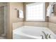 Clean bathroom with a soaking tub and a large window at 506 Misty Willow Way, Rolesville, NC 27571