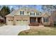 Brick two-story home with three-car garage and landscaped yard at 5312 Landguard Dr, Raleigh, NC 27613