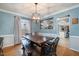 Bright dining room features a rustic wooden table, chandelier, and view into the kitchen at 5315 Oakbrook Dr, Durham, NC 27713