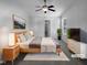 Virtually staged bedroom with wood bed frame, window, and ceiling fan at 54 Cape Ct, Clayton, NC 27520