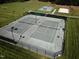 Aerial view of community tennis courts featuring two side-by-side courts and dark fencing at 64 Barn Owl, Pittsboro, NC 27312