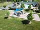 Aerial view of community playground with shade structure, slide, clubhouse, and pool area at 64 Barn Owl, Pittsboro, NC 27312