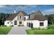 Beautiful two-story home showcasing stone and siding accents, complemented by a three-car garage and lush landscaping at 64 Barn Owl, Pittsboro, NC 27312