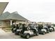 Row of golf carts parked outside the clubhouse, ready for a day on the course, showcasing recreational amenities at 64 Barn Owl, Pittsboro, NC 27312