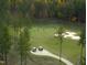 Scenic aerial of golfers on lush green course featuring mature trees and sand traps within a planned residential community at 64 Barn Owl, Pittsboro, NC 27312