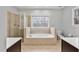 A luxurious bathroom featuring a large tub, separate shower, and bright natural light at 7416 Capulin Crest Dr, Apex, NC 27539