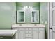 Bathroom with dual sinks, framed mirrors, updated fixtures and hardware, and green walls at 7416 Capulin Crest Dr, Apex, NC 27539