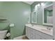 Bathroom with a double vanity and sink, framed mirrors, updated fixtures and green walls at 7416 Capulin Crest Dr, Apex, NC 27539