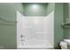 Shower and tub with white tile, green walls, and updated fixtures, along with storage at 7416 Capulin Crest Dr, Apex, NC 27539