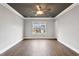 Empty bedroom with dark gray ceiling, wood floors, large window, and neutral walls at 7416 Capulin Crest Dr, Apex, NC 27539