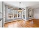 Bright breakfast area featuring hardwood floors, a large window with a view, and an elegant chandelier at 7416 Capulin Crest Dr, Apex, NC 27539