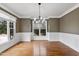 Bright dining room featuring hardwood floors, wainscoting, neutral paint, and large windows at 7416 Capulin Crest Dr, Apex, NC 27539