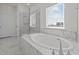 Elegant bathroom with soaking tub, glass shower, and marble tile at 800 Summit Crest Ct, Apex, NC 27523