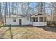 A white house featuring a lattice-designed screened porch and stone pathway in the backyard at 1014 Holden Rd, Youngsville, NC 27596