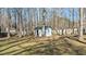 Backyard shed surrounded by mature trees and a fence at 1014 Holden Rd, Youngsville, NC 27596