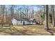 Charming rear exterior featuring a screened porch and fenced yard surrounded by mature trees at 1014 Holden Rd, Youngsville, NC 27596
