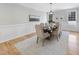 Formal dining room features wainscoting, natural light, and a large table with seating for eight at 109 Aspenridge Dr, Holly Springs, NC 27540